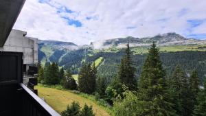 una vista di una valle con alberi e montagne di Résidence Iris - Studio entièrement rénové avec cabine · Centre station · Balcon MAE-4504 a Magland