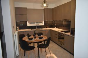 a kitchen with a wooden table and black chairs at BELLE VUE in Palaiá Panayía