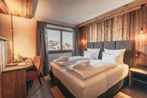 1 dormitorio con cama, escritorio y ventana en Hotel Piz Seteur, en Selva di Val Gardena