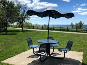 a table with chairs and an umbrella in a park at JORDAN'S NEST in Ajax