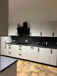 a kitchen with white cabinets and a black counter top at Privatzimmer in zentraler Lage in Geislingen (Steige) in Geislingen an der Steige