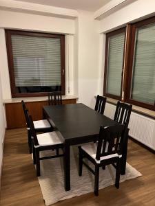 uma mesa preta e cadeiras num quarto com janelas em Privatzimmer in zentraler Lage in Geislingen (Steige) em Geislingen an der Steige