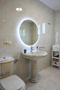 a bathroom with a sink and a toilet and a mirror at Apartamentos Costas de Bueu A in Bueu +15 photos