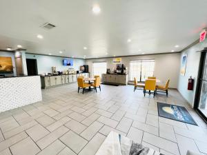 a lobby with a table and chairs and a kitchen at Days Inn & Suites by Wyndham - Canton First Monday Trade Days in Canton