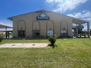 un edificio con un cartel que lee los días posada en Days Inn & Suites by Wyndham - Canton First Monday Trade Days, en Canton