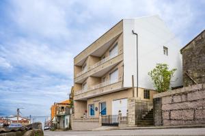 a white building on the side of a street at Apartamentos Costas de Bueu A in Bueu