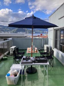 einen Tisch mit Sonnenschirm auf dem Balkon in der Unterkunft Atami-Ajironokaze - Vacation STAY 87959v in Atami