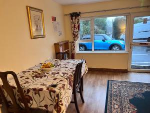 een kamer met een tafel en een auto buiten het raam bij Prestashortstays in Belfast