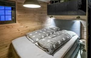 a bed in a room with a wooden wall at Awesome Home In seral With Wifi in Åseral