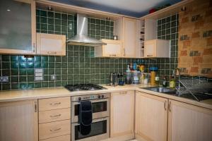 a kitchen with wooden cabinets and a stove top oven at 1-Bed Flat in Ocean Village in Southampton