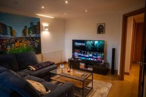 a living room with a couch and a tv at 1-Bed Flat in Ocean Village in Southampton