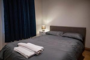 a bedroom with a bed with two towels on it at 1-Bed Flat in Ocean Village in Southampton