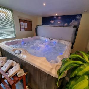 eine große Whirlpool-Badewanne in einem Zimmer mit Fenster in der Unterkunft Gîte BLEUET le petit LOFT, dans résidence et SPA in Ventron