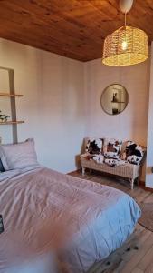 ein Schlafzimmer mit einem Bett und einem Sofa in einem Zimmer in der Unterkunft Maison atypique au grand charme in Embrun