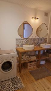 ein Badezimmer mit 2 Waschbecken und einer Waschmaschine in der Unterkunft Maison atypique au grand charme in Embrun