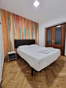 a bedroom with a large bed with white sheets at Calle Mayor, alójate en el centro histórico de Madrid in Madrid