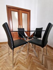 a dining room table with four chairs and a mirror at Calle Mayor, alójate en el centro histórico de Madrid in Madrid
