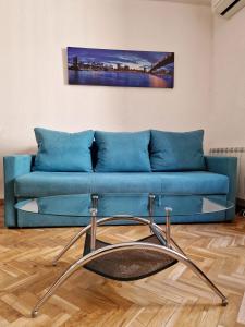 - un canapé bleu dans le salon orné d'une peinture murale dans l'établissement Calle Mayor, alójate en el centro histórico de Madrid, à Madrid