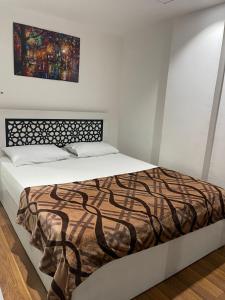 加利卜港的住宿－Marina City portghalib one bedroom，卧室内的一张床铺,墙上有绘画作品