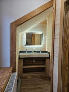 ein Bad mit einem Waschbecken und einem Spiegel in der Unterkunft Gîte BLEUET le petit LOFT, dans résidence et SPA in Ventron
