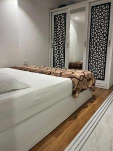 un letto bianco in una stanza con specchio di Marina City portghalib one bedroom a Port Ghalib