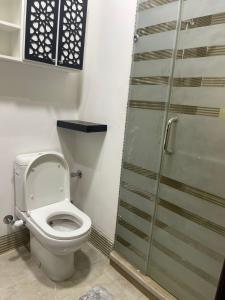 a bathroom with a toilet and a glass shower door at Marina City portghalib one bedroom in Port Ghalib