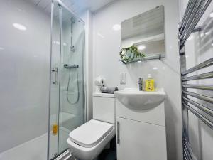 uma casa de banho com um lavatório e um chuveiro. em Chic Hideaway: Modern Studio in Stretford em Manchester