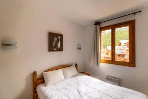 una camera con letto e finestra di Résidence Le Balcon Des Airelles - 2 Pièces pour 4 Personnes 344 a Les Orres