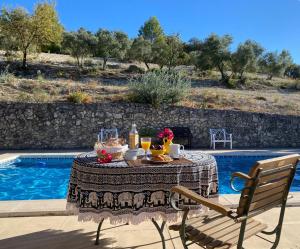 a table with food and drinks on it next to a pool at Viña Zarzarrosa Osuna in Osuna