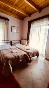 Duas camas num quarto com janelas em Villa Athamanio - Suite em Athamanio