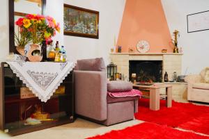 uma sala de estar com uma cadeira e uma lareira em Villa Athamanio - Suite em Athamanio