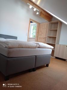 1 dormitorio con 1 cama en una habitación con ventana en Ferienhaus am Bach, en Achslach