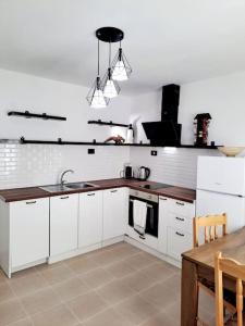 a kitchen with white cabinets and a sink and a table at White House Apartments in Haskovo