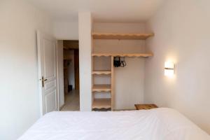 ein Schlafzimmer mit einem weißen Bett und einem Schrank in der Unterkunft Résidence Le Balcon Des Airelles - 2 Pièces pour 4 Personnes 494 in Les Orres