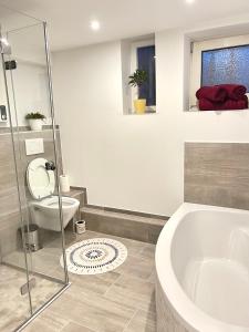 a bathroom with a tub and a toilet and a sink at Casa Bella in Guxhagen