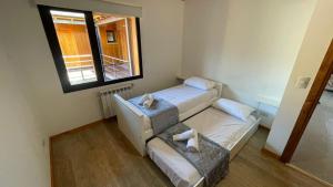 a small room with two beds and a window at Loretta - Sumando Latitudes in San Martín de los Andes
