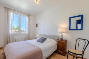 een slaapkamer met een bed, een stoel en een raam bij L'oranger - Villa avec piscine in Saint-Jean-de-Védas