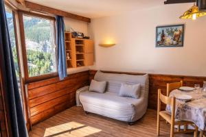 a living room with a couch and a table at Résidence Le Belvedere - Studio pour 4 Personnes 564 in Les Orres