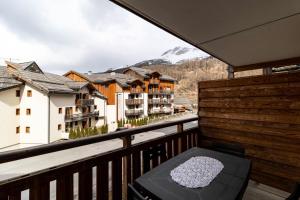 balcón con mesa y vistas a la montaña en Résidence Le Balcon Des Airelles - 2 Pièces pour 4 Personnes 634, en Les Orres