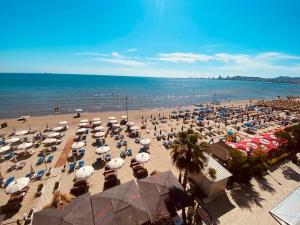 ein Strand mit vielen Sonnenschirmen und dem Meer in der Unterkunft Luxurious Dreamy seaside apartment in Durrës