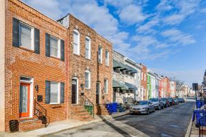 una fila de casas de ladrillo en una calle con coches aparcados en Charming Baltimore Getaway about 1 Mi to Downtown!, en Baltimore