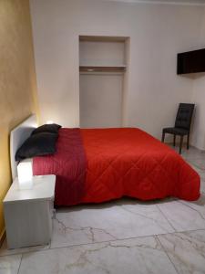 1 dormitorio con 1 cama roja y 1 silla en B&B Soleil, en Nicosia