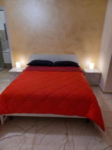 1 dormitorio con 1 cama roja y 2 mesitas de noche en B&B Soleil, en Nicosia