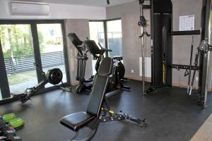 a gym with several treadmills and exercise bikes at Apartament Baltic&SPA - Aprent in Międzywodzie