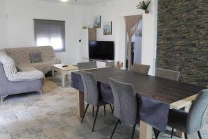 sala de estar con mesa, sillas y sofá en Chalet vacacional en Hondón de las Nieves