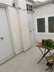 a patio with a bench and two garage doors at Apartamento Baeza 4A in Baeza