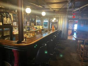een bar in een pub met een lang aanrecht en stoelen bij Gamble Farm Inn and Suites 