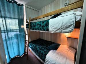 a bedroom with two bunk beds and a window at Résidence Tougnette - Studio pour 3 Personnes 494 in Les Menuires