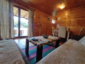 une chambre avec une table dans une cabane en rondins dans l'établissement Coso House Ada Bojana, à Ulcinj