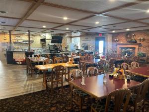 a restaurant with wooden tables and chairs in a room at Gamble Farm Inn and Suites in Jersey Shore